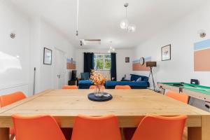 a dining room with a table with orange chairs at The Two-Bedroom Haven- Sleeps 10 in St. Albans