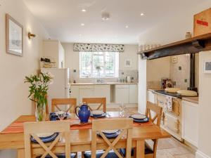 a kitchen and dining room with a wooden table and chairs at 3 Bed in Tiverton 53565 in Cullompton