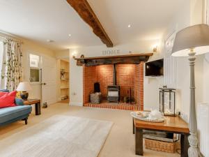 a living room with a fireplace and a blue couch at 3 Bed in Tiverton 53565 in Cullompton