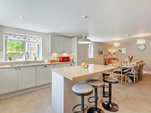 uma cozinha com um balcão e uma mesa com bancos em 4 Bed in Kirkby Lonsdale 54457 em Whittington