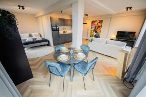 a living room with a table and blue chairs at Alphabet Studio Apartments Penthouse KS71 in Hilversum