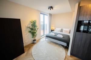 a bedroom with a bed and a large window at Alphabet Studio Apartments Penthouse KS71 in Hilversum