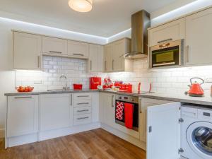 a kitchen with white cabinets and a washer and dryer at 2 Bed in Brixham 54679 in Brixham