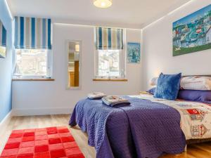 a bedroom with a purple bed and windows at 2 Bed in Brixham 54679 in Brixham