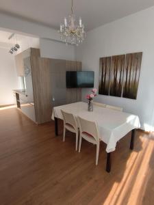 a dining room with a white table and chairs at Apartmens Kimm II in Poreč
