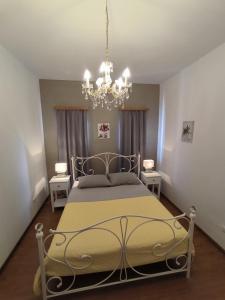 a bedroom with a bed and a chandelier at Apartmens Kimm II in Poreč