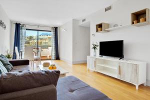 sala de estar con sofá y TV de pantalla plana en Carihuela Playa by IVI Real Estate, en Torremolinos