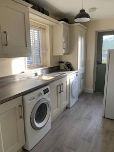 una cucina con lavandino e lavatrice di Modern 3 bed, detached house a Newry