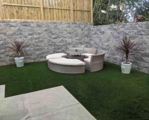 un patio con 2 divani, un tavolo e piante di Modern 3 bed, detached house a Newry