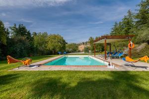 a swimming pool with chairs and a gazebo at Casale Fontocchio in Cortona