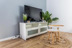 uma sala de estar com uma televisão e um banco em Le Refuge des Grands Rassemblements em Châteaudun