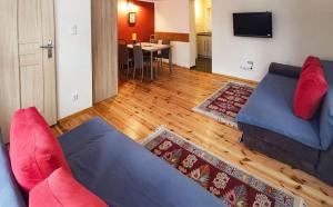 a living room with a blue couch and red pillows at Koniecznie Róża in Karpacz