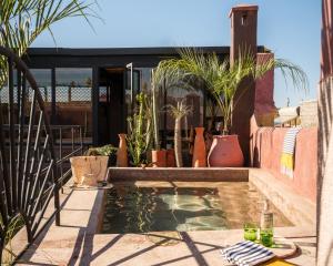 a small pool of water on a patio with plants at Riad Brummell Medina in Marrakesh