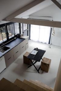 a kitchen with a table and some windows at PYLA: Nice creative studio 200 m from the beach in La Teste-de-Buch