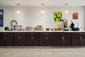 a kitchen with black cabinets and a counter top at La Quinta Inn by Wyndham Victoria in Victoria