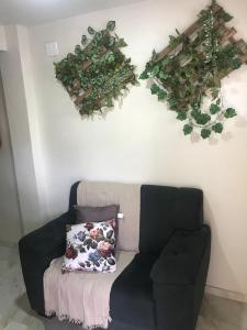 a living room with a couch and plants on the wall at Residencial Estrela Guia 2 in Cabo Frio