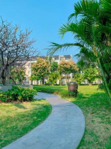 una passerella in un parco con una palma di Royal Lotus Hạ Long Resort - kiko resort a Ha Long