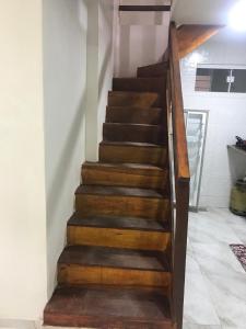 a wooden staircase with wooden treads in a room at Residencial Estrela Guia 2 in Cabo Frio
