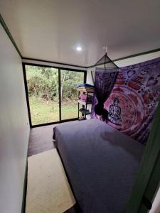 a bedroom with a bed in a room with a window at La Cabaña del Bosque in Delicias