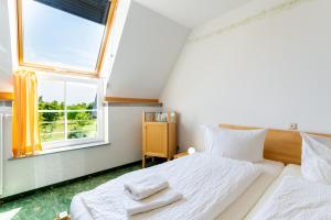 a bedroom with two beds and a window at Hotel Bördehof in Barleben