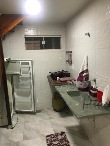 a kitchen with a sink and a refrigerator in it at Residencial Estrela Guia 2 in Cabo Frio