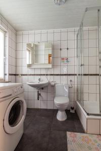 a bathroom with a toilet a sink and a washing machine at Zweibettzimmer in Bitterfeld-Wolfen, Haus mit Gemeinschaftsküche und -Bad für Monteure in Steinfurth