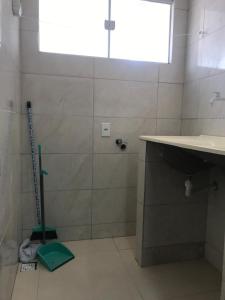 a bathroom with a sink and a shower with a mop at Residencial Estrela Guia 2 in Cabo Frio