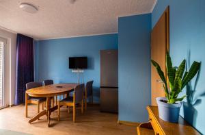 a dining room with a table and a blue wall at Zweibettzimmer in Bitterfeld-Wolfen, Haus mit Gemeinschaftsküche und -Bad für Monteure in Steinfurth