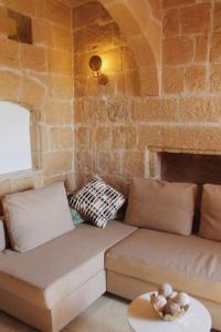 a living room with a couch and a brick wall at Studio Barrakka Gardens in Valletta
