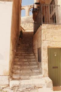 a set of stairs with a green door on a building at Studio Barrakka Gardens in Valletta