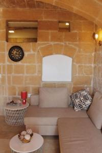 a living room with a couch and a stone wall at Studio Barrakka Gardens in Valletta