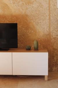 a white cabinet with a television on top of it at Studio Barrakka Gardens in Valletta