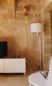 a living room with a tv and a table with a lamp at Studio Barrakka Gardens in Valletta