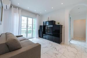 un salon avec un canapé et une télévision dans l'établissement LOUIS GALLET Centre JUAN LES PINS 50m des plages, à Antibes