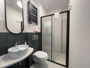 La salle de bains est pourvue de toilettes, d'un lavabo et d'une douche. dans l'établissement Promień Słońca, à Świnoujście