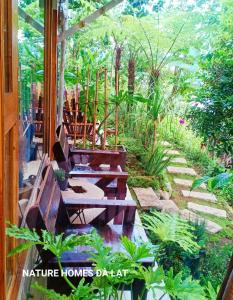 a patio with benches and plants in a garden at Nature Homes Đà Lạt in Da Lat