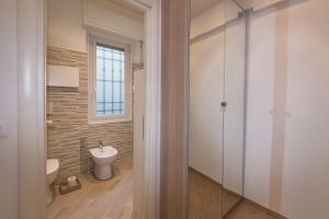 Un baño con inodoro blanco y ventana. en Spiaggia e Gaslini, en Génova 19 fotos más
