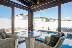 a patio with a table and chairs and a pool at Chalet Estribor in Chiclana de la Frontera