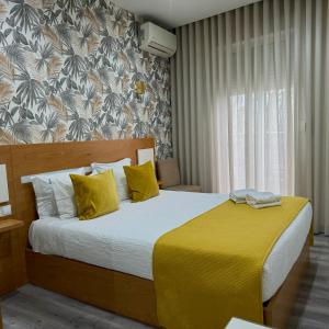 sypialnia z dużym łóżkiem i żółtym kocem w obiekcie GuestHouse Marquês w Porto