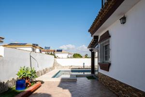 a house with a swimming pool next to a building at Chalet Estribor in Chiclana de la Frontera