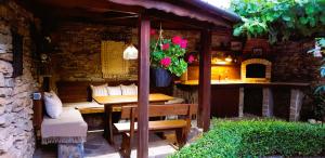 una mesa y un banco bajo un pabellón en un jardín en Семеен Хотел Берое en Stara Zagora