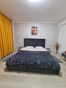 ein Schlafzimmer mit einem großen Bett und gelben Vorhängen in der Unterkunft Studio By Raisa in Braşov
