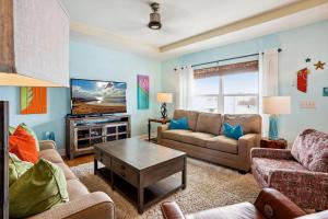 a living room with a couch and a tv at Gulfport Getaway in St. Petersburg