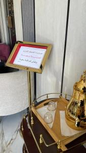 a table with a sign and a tea kettle on it at NIYAMA LAND HOTEL in Umm Lujj