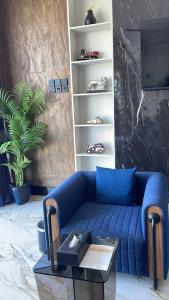 a living room with a blue couch and a tv at Niyama Hotel in Umm Lujj
