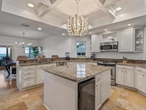 a large kitchen with white cabinets and a chandelier at Walks On The Shore in Clearwater Beach