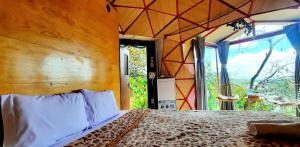 um quarto com uma cama e uma grande janela em Nature Homes Đà Lạt em Da Lat