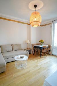 a living room with a couch and a table at Villa Escudier Appart-hôtel in Boulogne-Billancourt