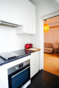 - une cuisine équipée d'un four avec plaques de cuisson en noir et blanc dans l'établissement Villa Escudier Appart-hôtel, à Boulogne-Billancourt