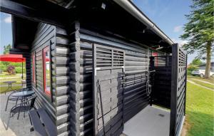 una vista laterale di un capannone nero con un patio di Two-Bedroom Holiday Home In Nordborg a Nordborg